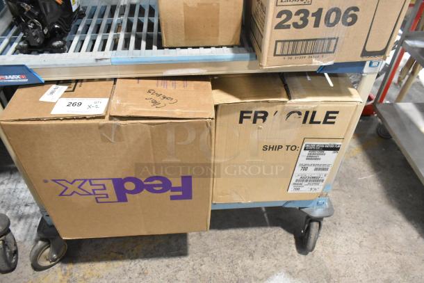 Boxes of new Lancaster Table & Seating Black Chiavari Chair Cushions with Ties, 2" thick, visible labels, on cart.