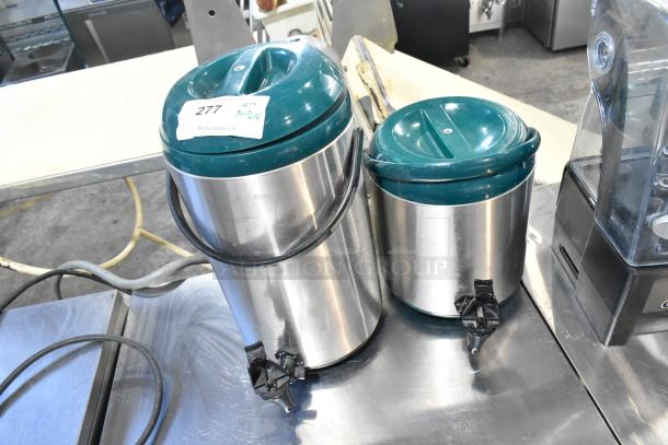 Two stainless steel beverage dispensers with teal plastic lids, spouts, and handles. Visible sticker: "277 QTY 2".