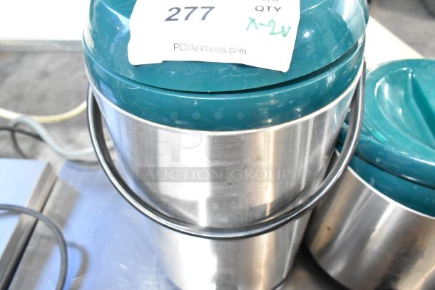 Two metal beverage holder dispensers with green lids and handles, label indicates item number 277, auctioned by PCIAuctions.com.