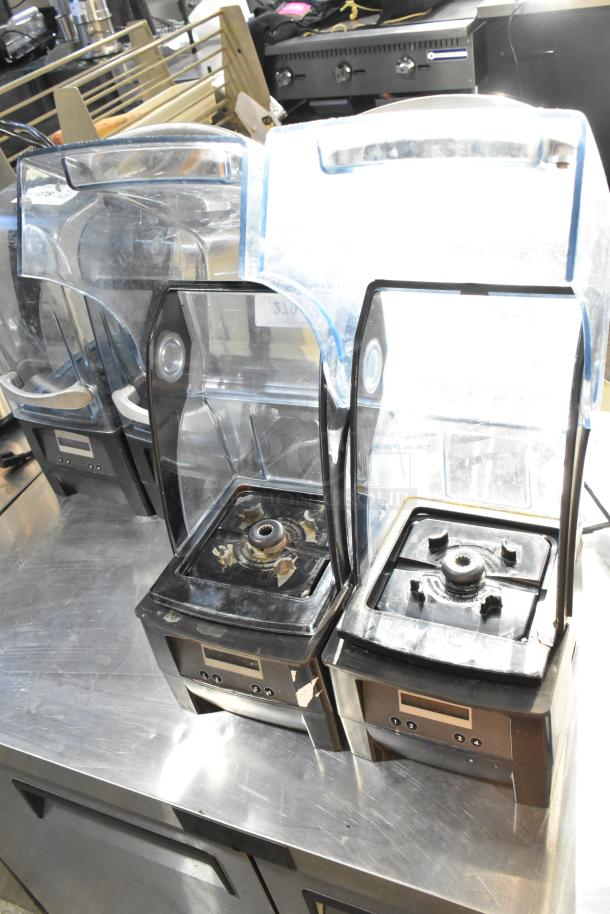 2 VitaMix VM0145 countertop blenders with sound enclosures, metal base, 120V, shown on stainless steel surface.