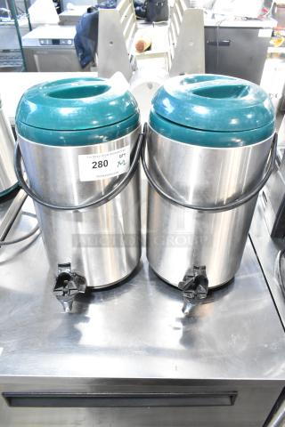 2 stainless steel beverage dispensers with teal lids, tap spouts, and carrying handles. Auction label: "280 QTY x2."