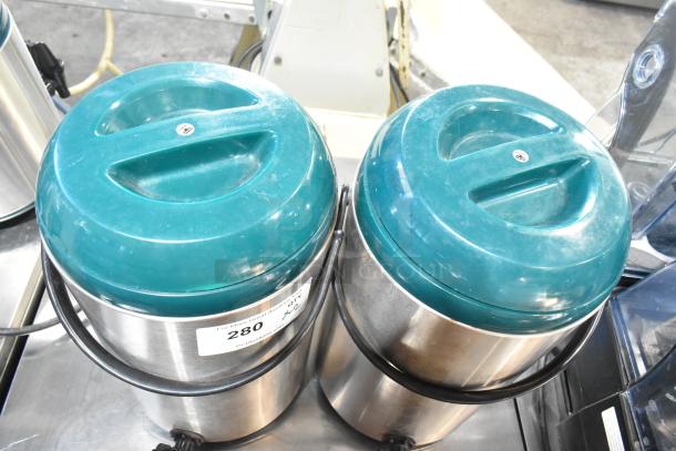 Two metal beverage holder dispensers with teal lids and black handles, labeled "280", in good condition.