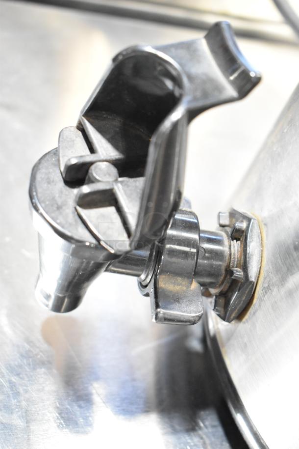 Metal beverage holder spout close-up, showing sleek design and reflective finish, part of an auction for two dispensers.