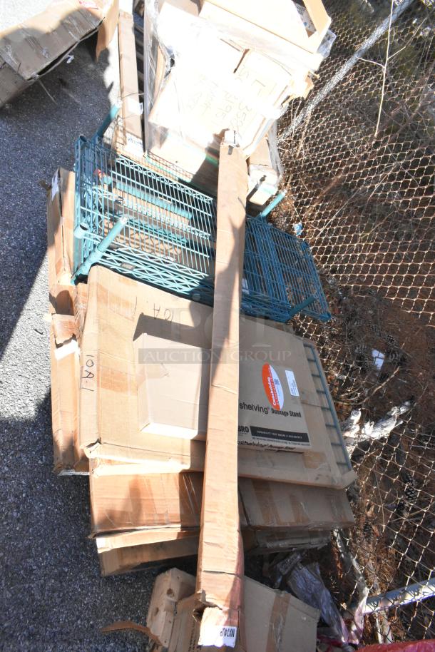 Packaging containing new items, including John Boos PB-SS-208 Portable Soak Sink, shelves, and poles, on asphalt.