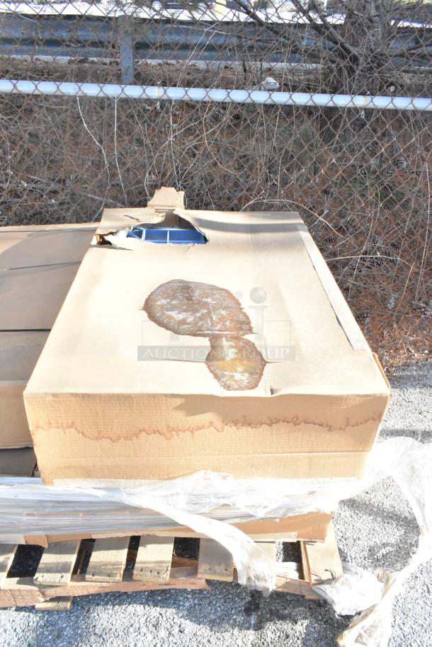 Four new items in a partially damaged cardboard box on a pallet, including a blue Metro BC2636-3DMB Deep Ledge Utility Cart.