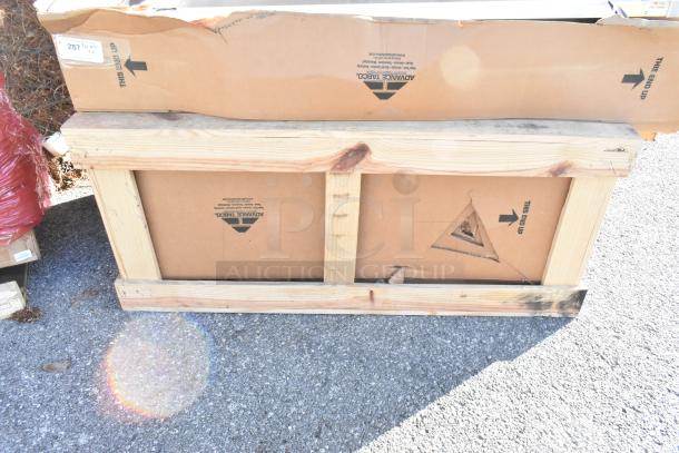 Two brand-new Advance Tabco work tables in original packaging, featuring stainless steel construction, a 5" backsplash, undershelf, and prep sink.