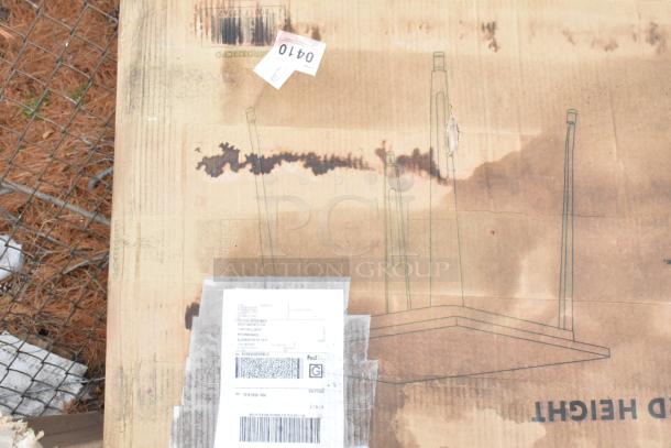 Cardboard box with visible damage and shipping labels, containing new scratch and dent items like a speed rail and dump sink.