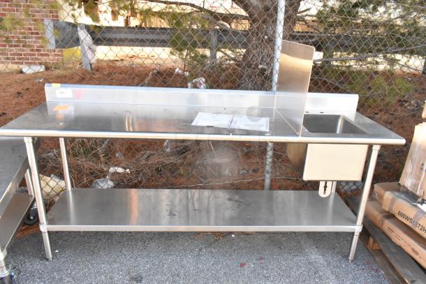 Stainless steel table with sink bay, backsplash, and under shelf. Features a clean surface and sturdy frame for durability.