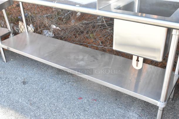 Stainless steel table with sink bay, back splash, and under shelf. Features durable construction and ample storage space.