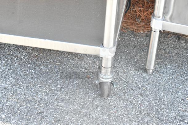 Stainless steel equipment stand with under shelf and commercial casters, showcasing durable construction and mobility.