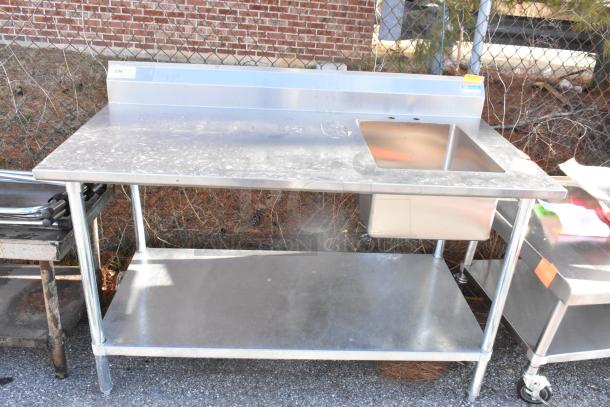 Stainless steel table with integrated sink bay, backsplash, and under shelf. Used condition with visible wear.