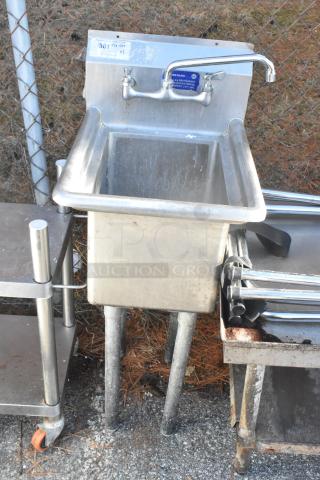 Stainless steel single bay sink with high-rise faucet, moderate wear. Markings indicate restaurant-grade manufacturing.