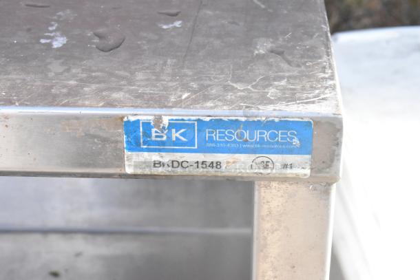 Stainless steel table with 2 under shelves, labeled "BK Resources BDC-1548," showing moderate wear.