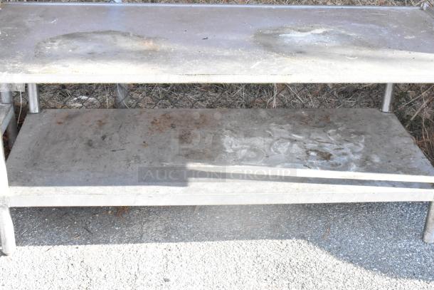 Stainless steel equipment stand with a metal under shelf, showing surface wear and rust marks, suitable for industrial use.