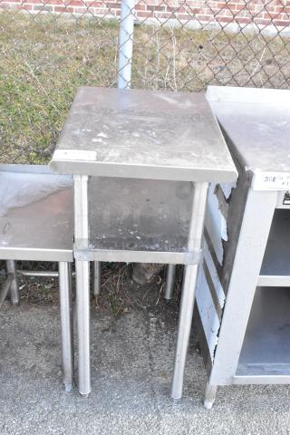 Stainless steel table with metal under shelf, shows signs of wear, suitable for industrial use.