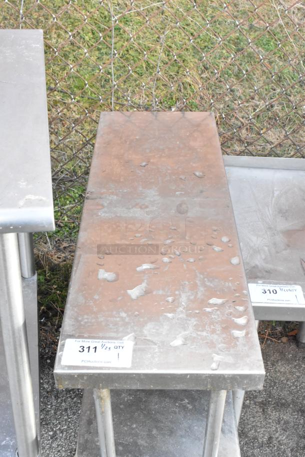 Stainless steel two-tier overshelf with visible surface wear. Auction tag reads "311, 1/25 QTY, PCIauctions.com."