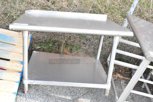 Stainless steel table with metal under shelf, used condition. Features a solid work surface and sturdy construction. Perfect for industrial settings.