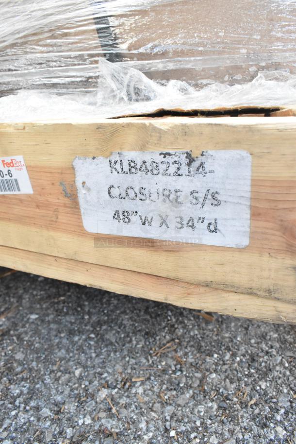 Pallet with wrapped items, FedEx label, and markings showing "KLB48224 Closure S/S 48''W X 34''D". Auction of new scratch and dent outdoor table bases.