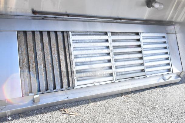 8' stainless steel grease hood with filters and lights, showing signs of use with visible rust. Ideal for ventilation systems.