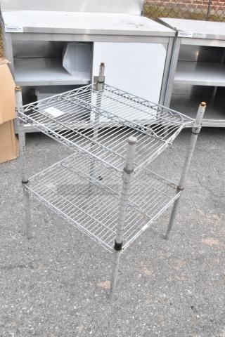 Chrome finish 2-tier wire shelving unit, dual shelves, sturdy metal construction, light wear, ideal for storage solutions.
