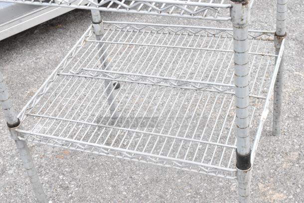 Chrome finish 2-tier wire shelving unit, weathered, with adjustable height markers on legs. Ideal for home or garage storage.