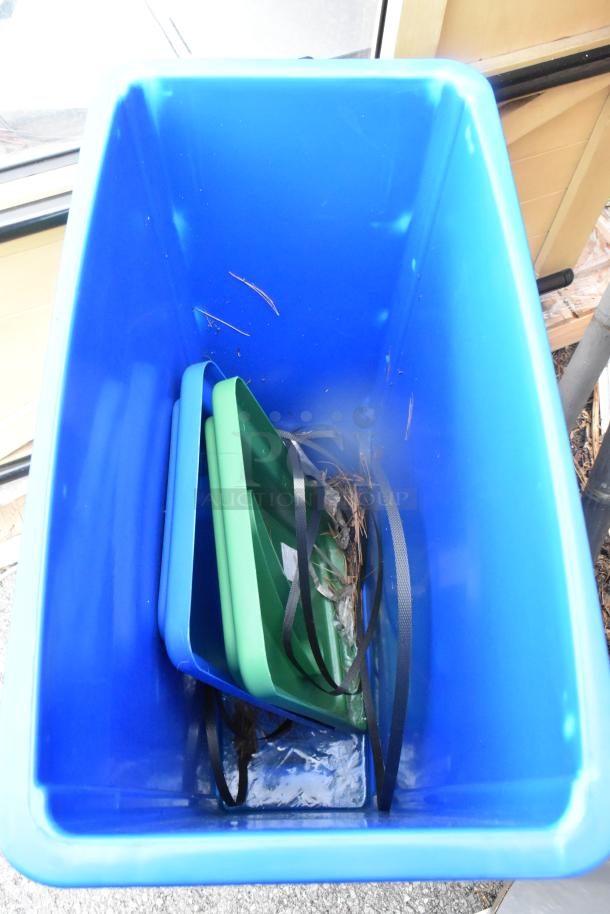 Blue Poly Slim Jim trash can containing mismatched lids and straps, visible wear. Auction includes two units.