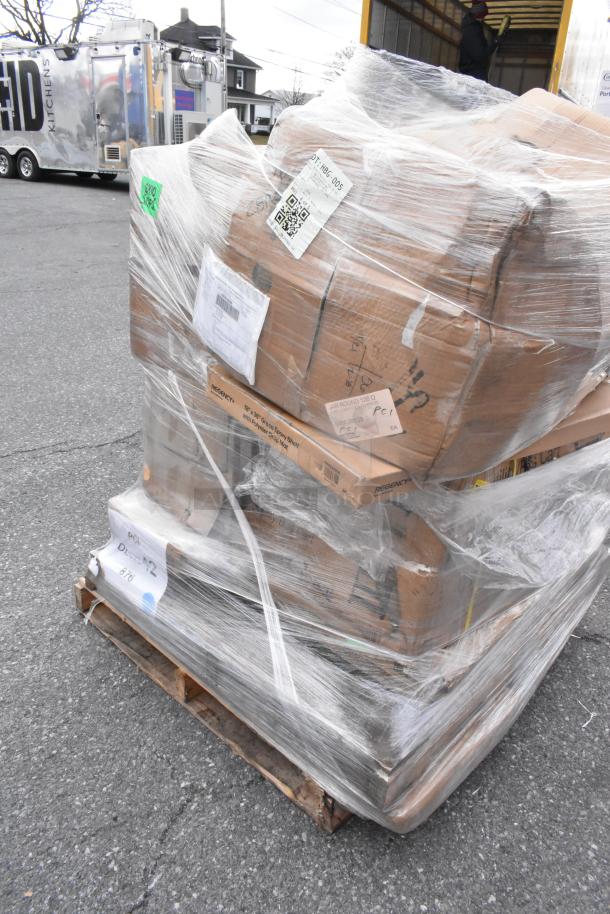 Pallet of assorted new scratch and dent items wrapped in plastic, including boxes labeled "Regency" and visible barcodes.