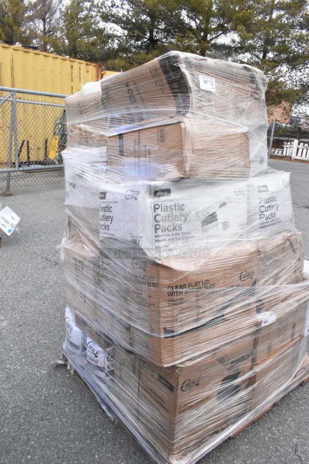 Pallet of wrapped boxes labeled "Plastic Cutlery Packs" and "Clear Flat Lid" in new condition, stored outdoors.