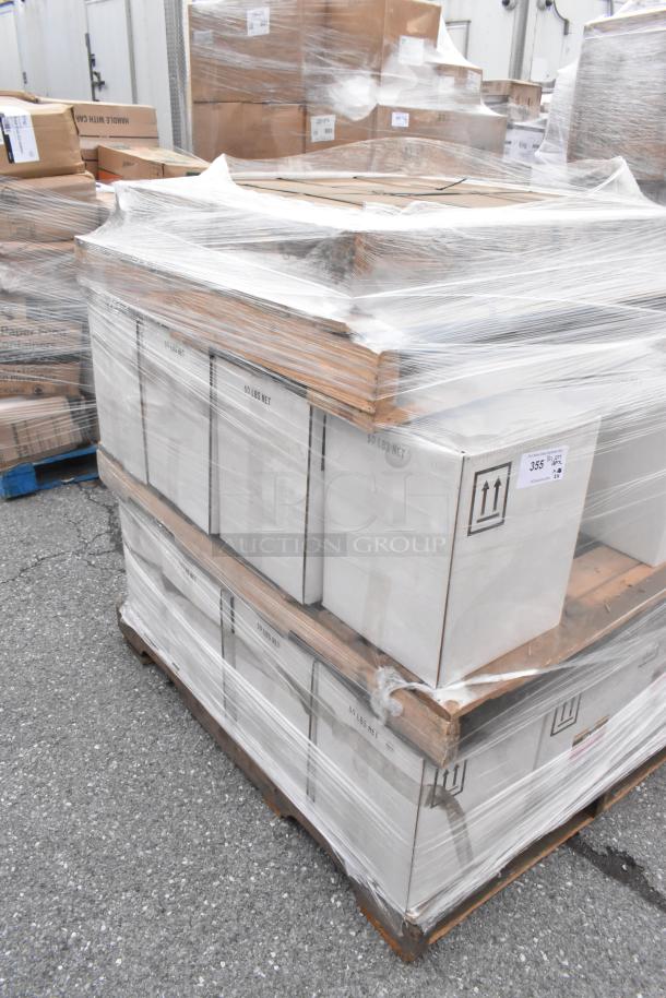 Stacked pallets wrapped in plastic containing 24 boxes of new scratch and dent items, including Pink Suds Powdered Hand Dishwash.
