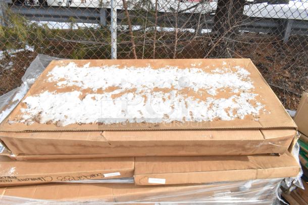 Cardboard boxes containing new scratch and dent items, partially covered with snow, labels indicate contents are Quantum Food Service and Metro shelves.
