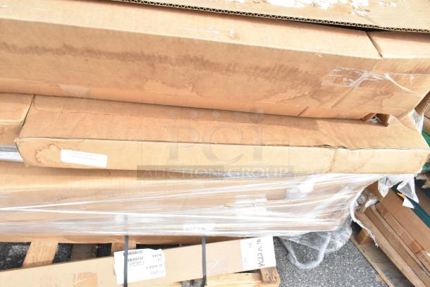 Stack of packaged items including P63P Quantum post, MetroMax i solid shelf, in cardboard boxes on pallets.