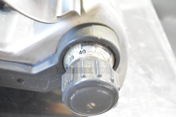 Hobart 2612 meat slicer dial close-up, showing adjustable thickness settings. Durable stainless steel construction.