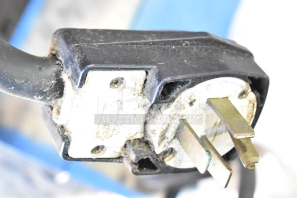 Close-up of an electric plug, likely for a Turbochef HhC2020 conveyor oven, showing prongs and signs of wear.