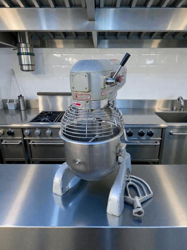 Commercial UPM-M20-3 20 Qt Planetary Mixer, silver, excellent condition, tested, 110V, includes attachments, industrial kitchen setting.