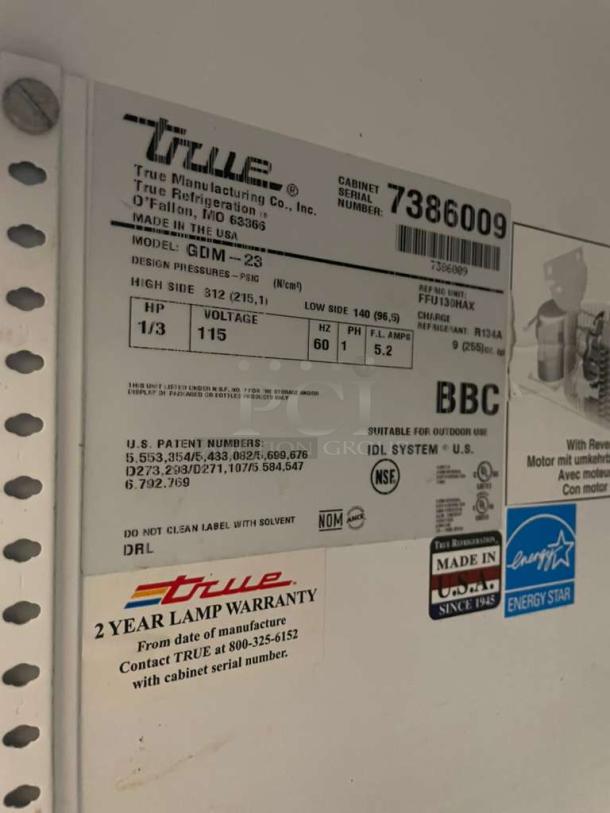 True GDM-23 Merchandiser Refrigerator label showing model, serial number, 115V voltage, NSF certification, and warranty info.
