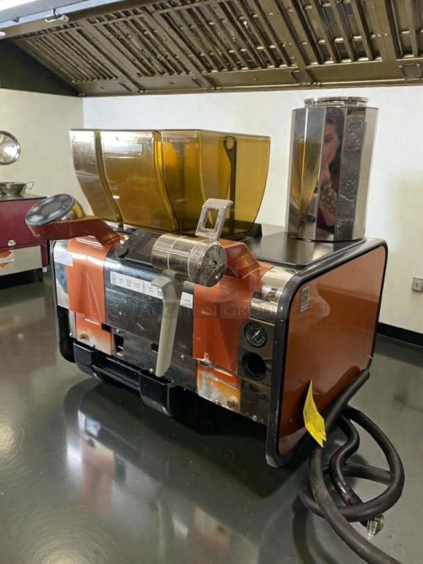 Nuova Simonelli Mythos Series commercial ice maker, excellent condition, features orange and metal finish, visible hoses.