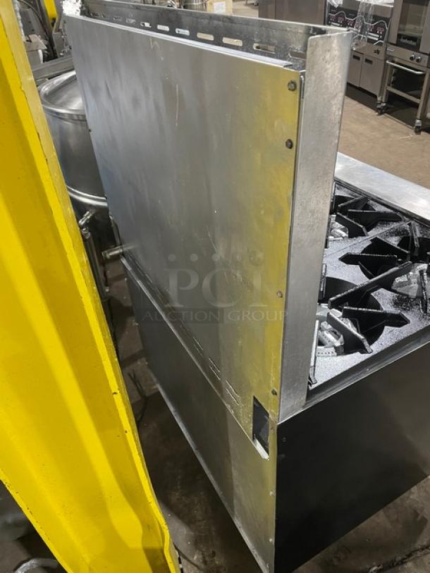 Tri-Star stainless steel gas-powered 6-burner range/oven combo with backsplash and wired oven rack, in used condition.