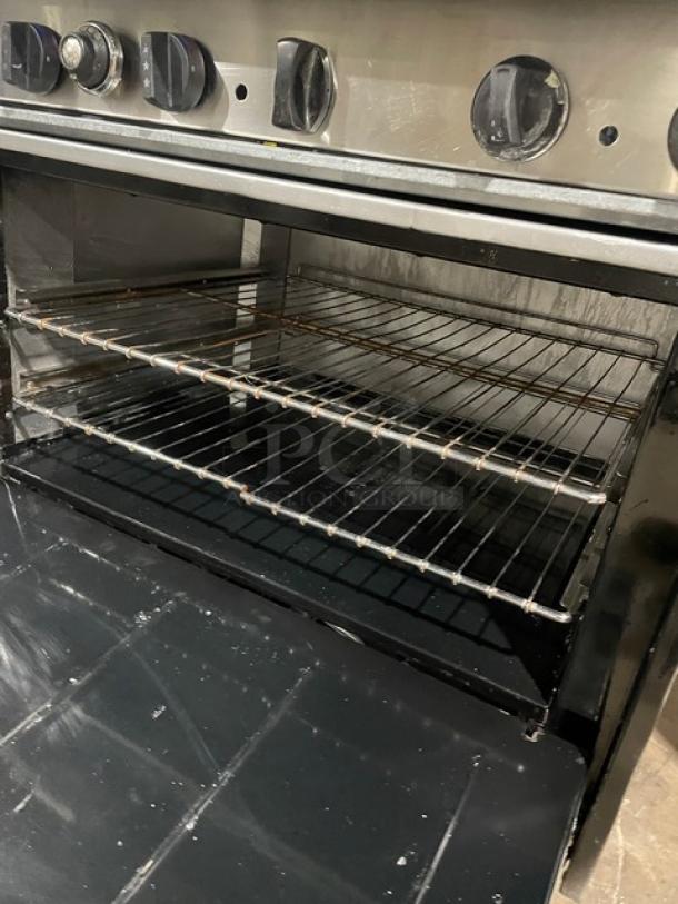 Tri-Star stainless steel gas-powered 6-burner range/oven combo with back splash and wired oven rack, in used condition.