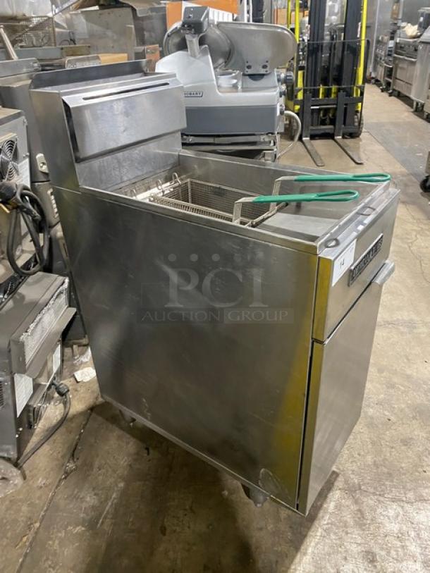 American Range stainless steel commercial gas fryer with backsplash, basket hanger, and fry basket. In good condition, on legs.