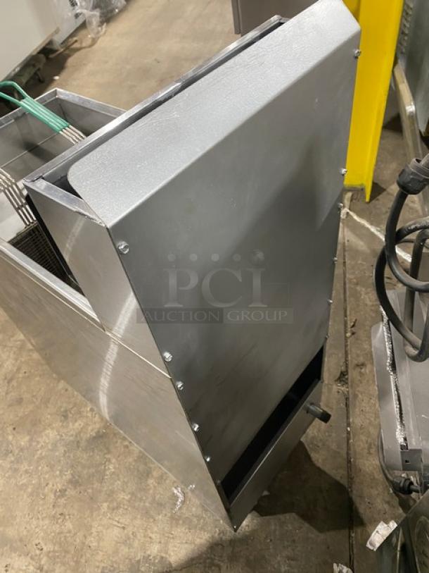 American Range stainless steel gas fryer with backsplash, basket hanger, and fry basket. Commercial grade, on legs.