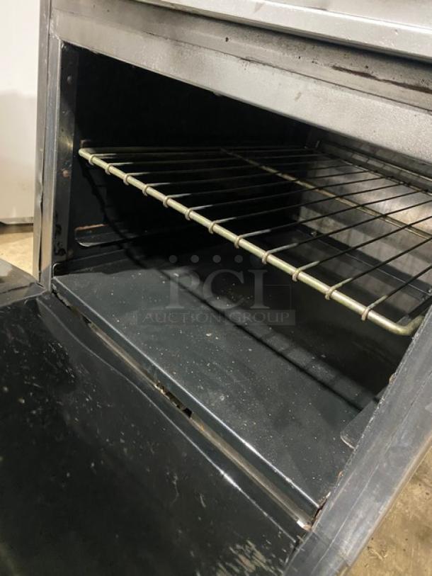 American Range stainless steel 4-burner gas range/oven with wired rack, backsplash, salamander shelf, on casters.