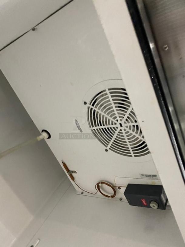 True commercial stainless steel combination half-door refrigerator, model T-231-G-1. Interior view showing wiring and fan.