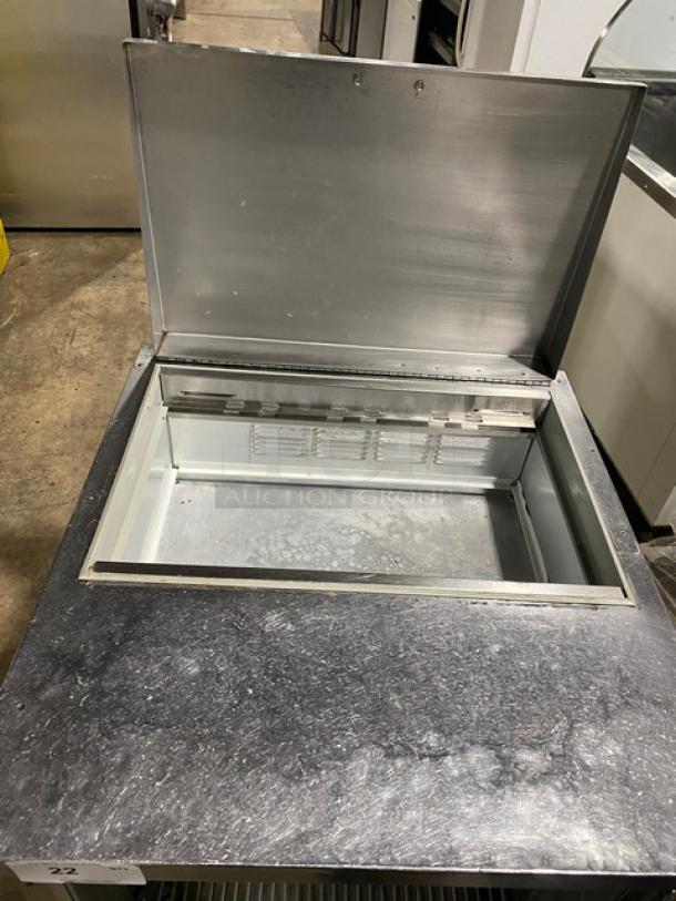 Beverage-Air stainless steel refrigerated prep table, model SP27, with open lid, wired rack, on casters, 115V, single door.