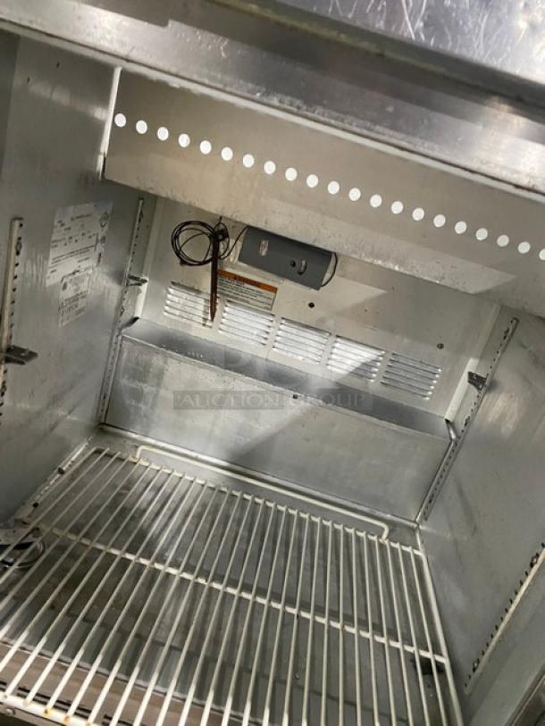 Beverage-Air SP27 refrigerated prep table interior with poly-coated wire rack, stainless steel, 115V, on casters, model SN: 8108534.