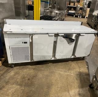 Custom Cool stainless steel 3-door refrigerated worktop table, 93" with upturned backsplash, built-in pan rack, model LB93, on casters.