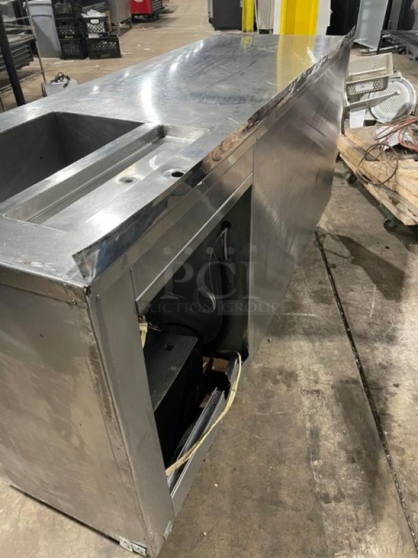 Commercial stainless steel refrigerated worktop station, two doors, single compartment sink, on legs, used condition.