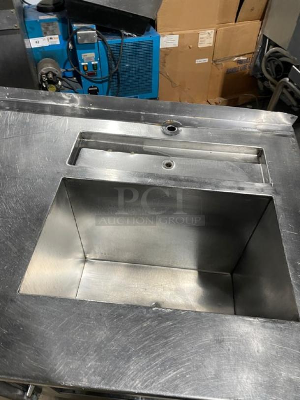 Commercial stainless steel 2-door refrigerated worktop station with single compartment sink, on legs, in used condition.