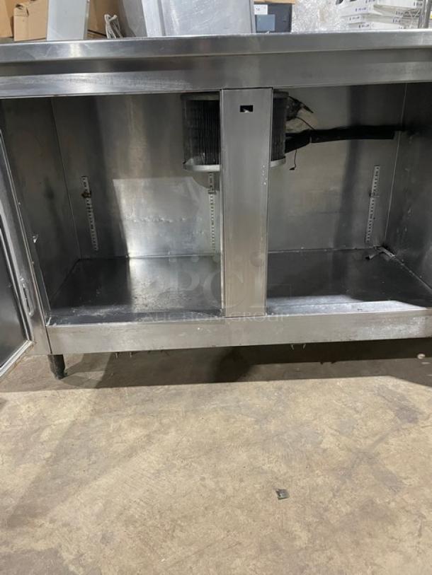 Stainless steel 2-door refrigerated worktop station with a single compartment sink, mounted on legs. Good condition.