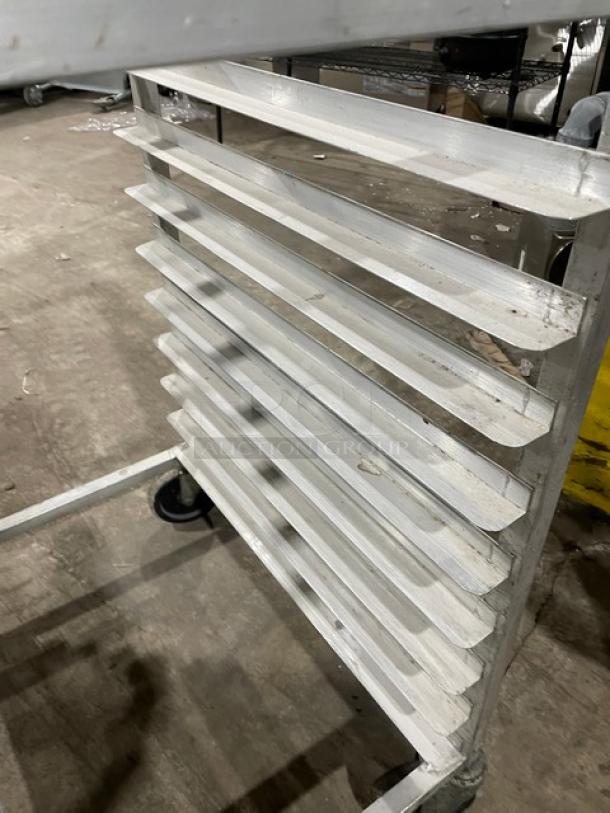 Commercial aluminum half-size heavy duty bun/sheet pan rack with slots, on casters, in good condition.