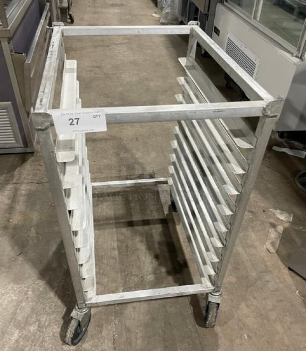 Commercial aluminum half-size heavy-duty bun/sheet pan rack on casters, in good condition, 10 slots, marked “27 QTY.”
